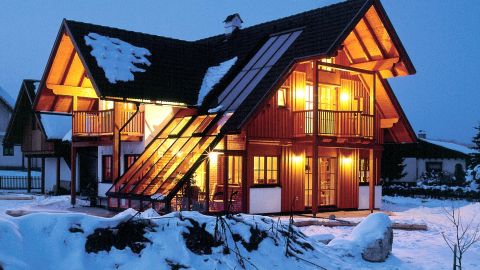 mit schneebedecktes beleuchtetes Haus mit vielen Fenstern