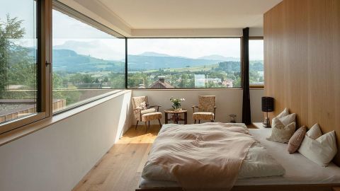 Schlafzimmer mit großen Holz-Fenstern