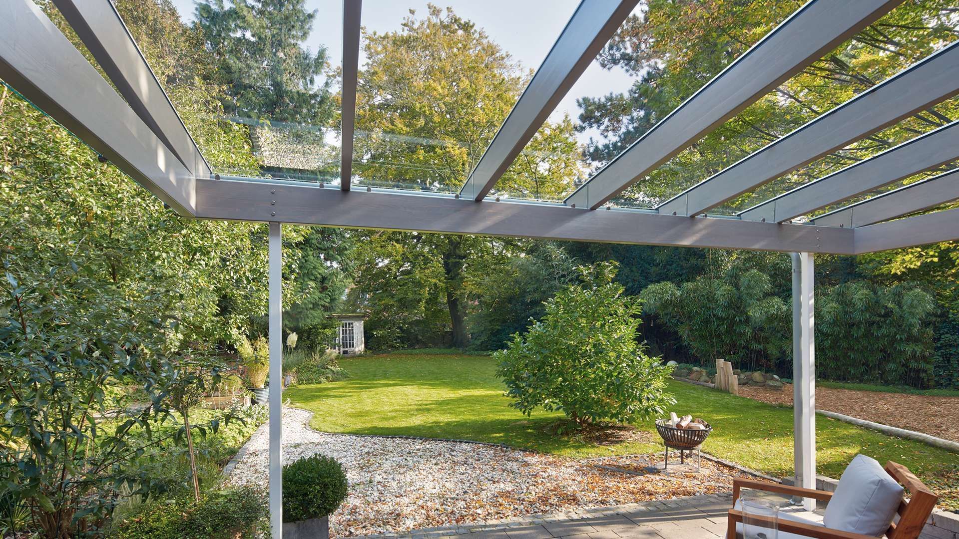 Innenansicht eines SDL Aura Terrassendachs mit Bild in einen herbstlichen Garten