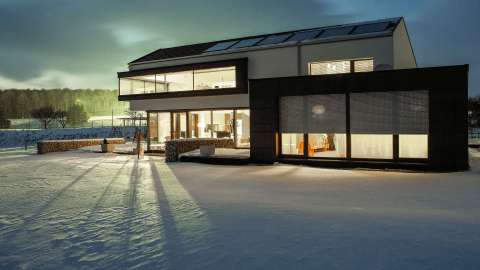 modernes Wohnhaus im Schnee mit Rollläden vor den Fenstern