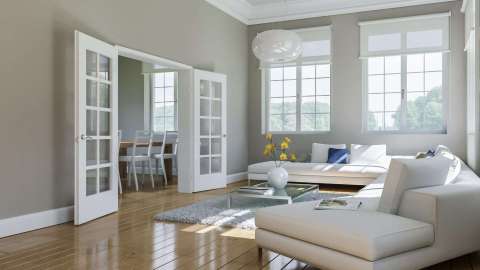 Blick in eine helles Wohnzimmer mit zwei großen Fenstern
