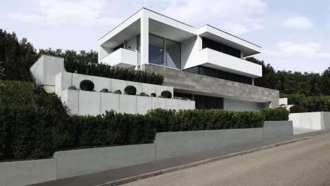 modernes weißes Haus mit Flachdach an einer Straße