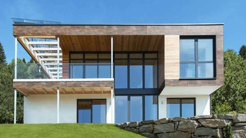 Modernes Haus mit Flachdach, Holzakzenten und großen Glasfasseden