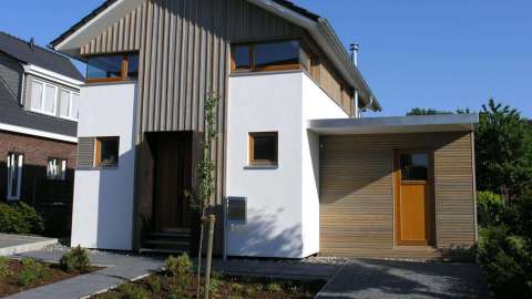 Wohnhaus mit Holzpanelen und Holzhaustür