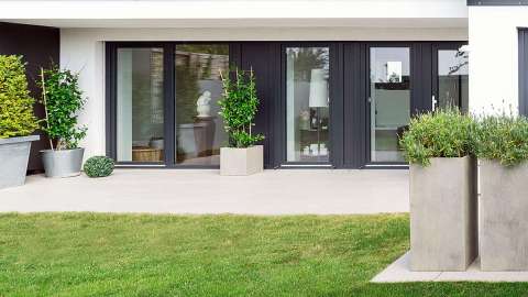 bodentiefe Aluminium-Fenster von Gugelfuss an einer Terrasse mit großem Garten