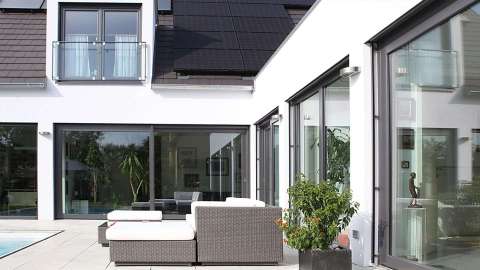 große Terrasse mit Pool und Gartenmöbeln an einem Haus mit Kunststoff-Fenstern von Gugelfuss