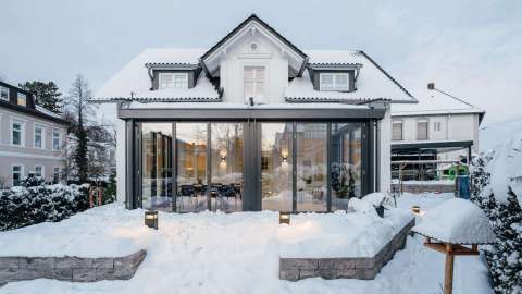 Wintergarten an einem Wohnhaus im Schnee