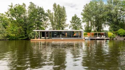 Haus mit Glas-Faltwand an einem Fluss