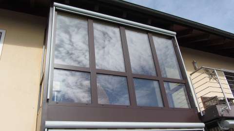 Fassade mit braunem Vorbau mit bodentiefen Fenstern