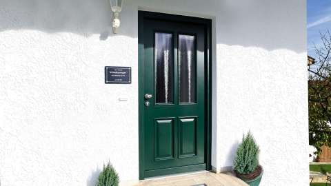 grüne Haustür in weißer Fassade