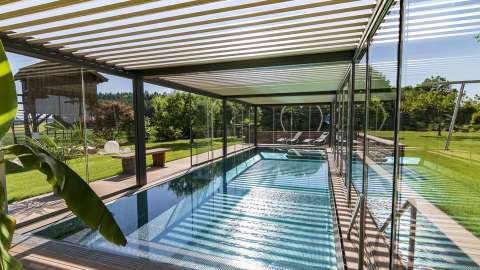 großer Pool mit Lamellendach und Glas-Schiebesystem an den Seiten
