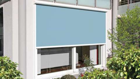 bodentiefes Fenster unter einem Balkon mit hellblauer Senkrechtmarkise