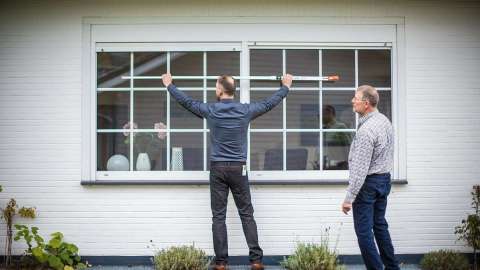 zwei Männer messen ein Fenster aus