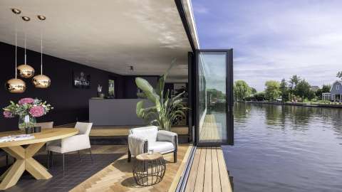 Glas-Faltwand von Solarlux öffnet das Hausboot zum Wasser hin auf voller Breite