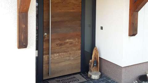 Haustür aus Holz mit Glaselementen auf beiden Seiten in weißer Fassade
