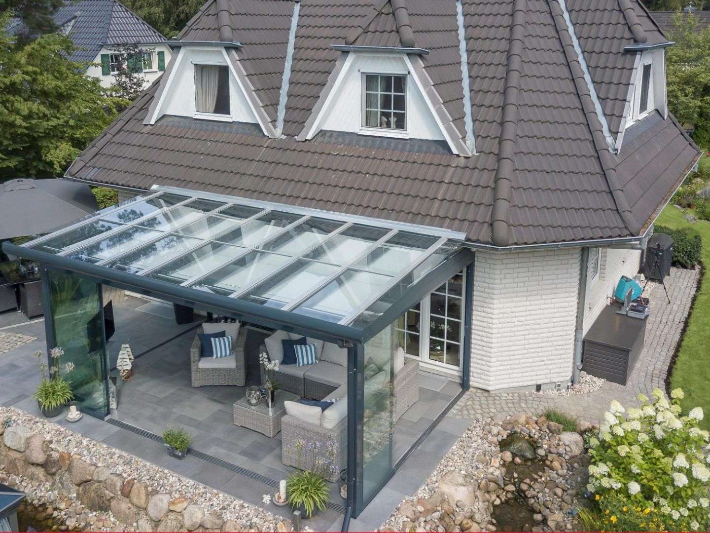 Glashaus an einem Einfamilienhaus aus der Vogelperspektive