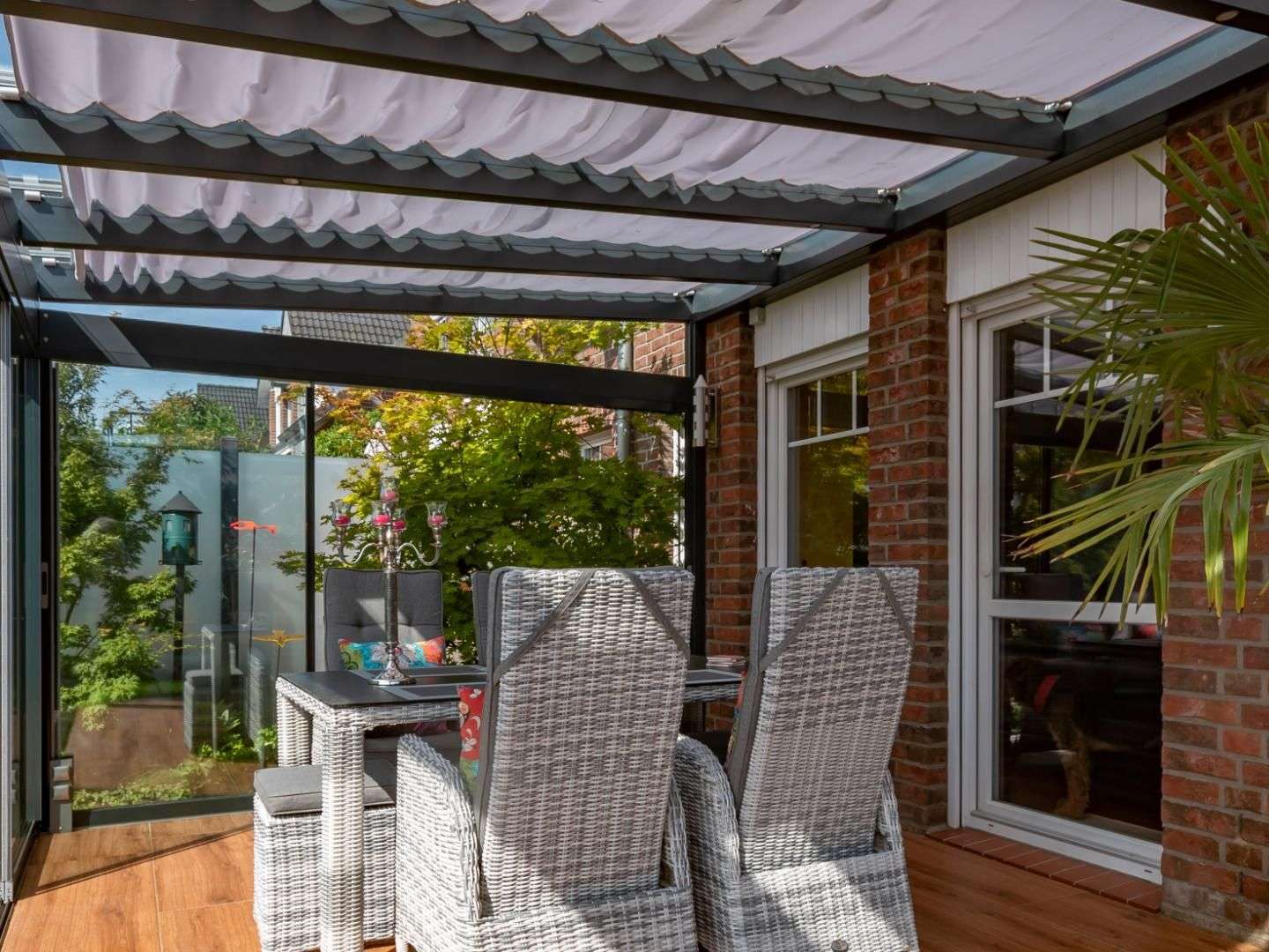 Peddy Shield Seilspann-Sonnensegel in einem Glashaus mit Esstisch