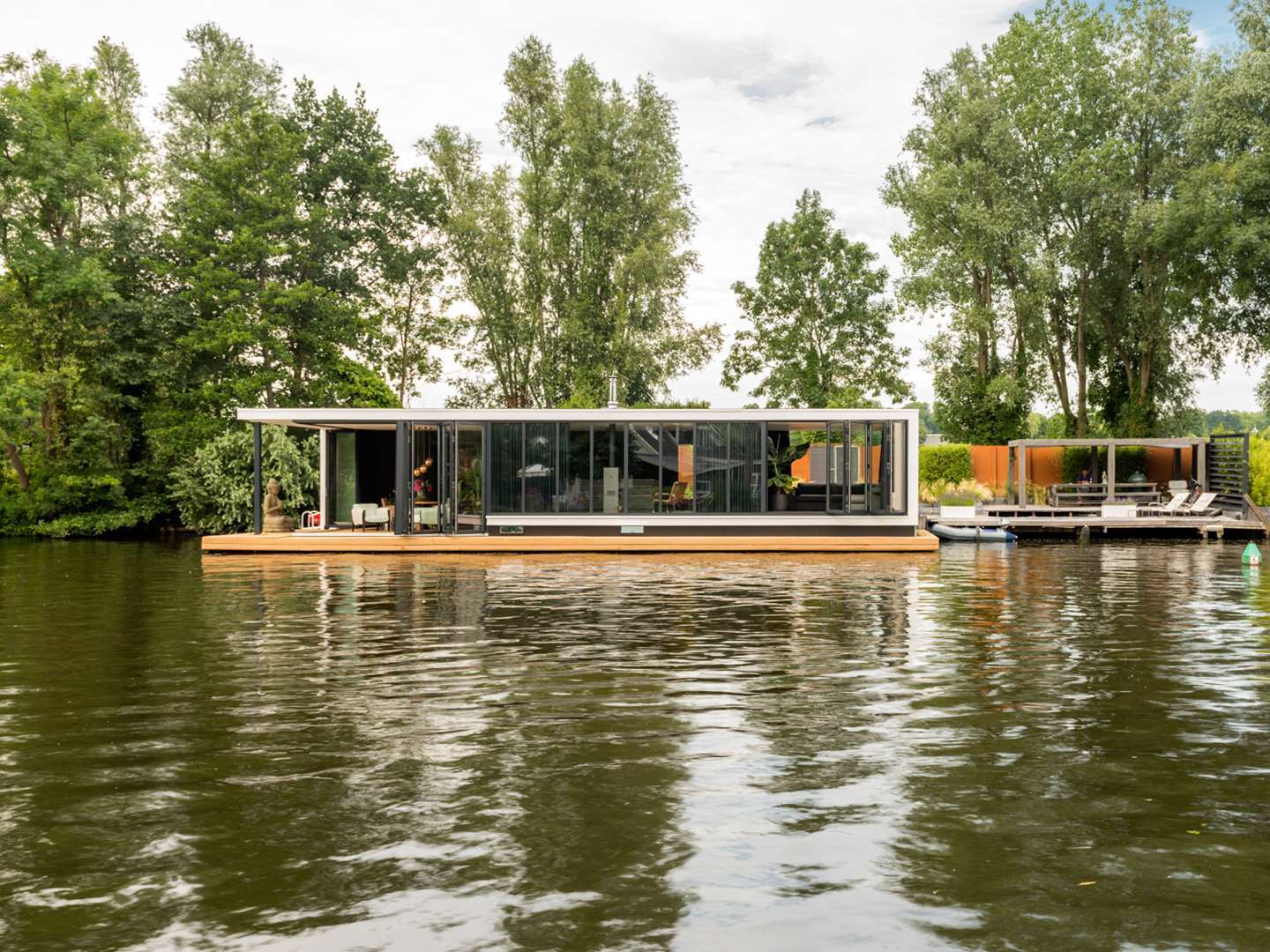 Haus mit Glas-Faltwand an einem Fluss