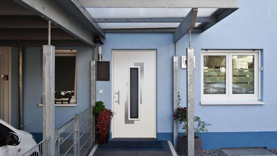 Kompotherm Haustür im Chagall-Design in einem hellblauen Haus mit Überdachung zur Haustür hin
