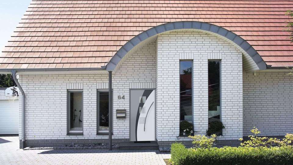 Kompotherm Haustür im E-Design in einem Haus aus weißem Klinker und rundem Dachvorsprung