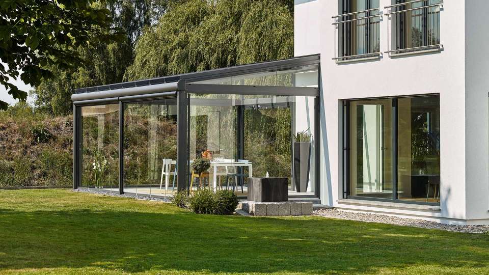 Glashaus auf der Terrasse eines Wohnhauses mit Garten