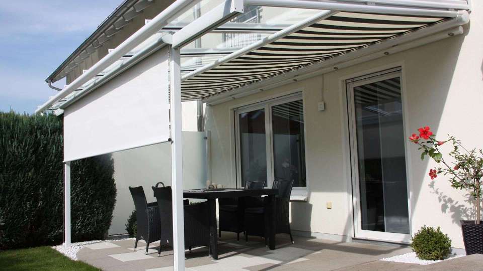Terrasse mit gestreifter Markise und seitlichen Sonnenschutz