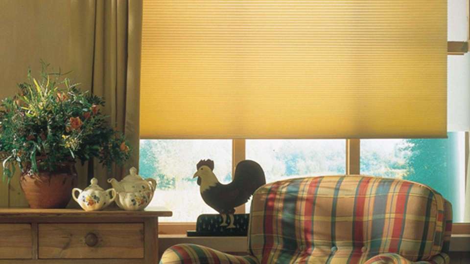 Sessel vor einem Fenster mit gelber Innenjalousie